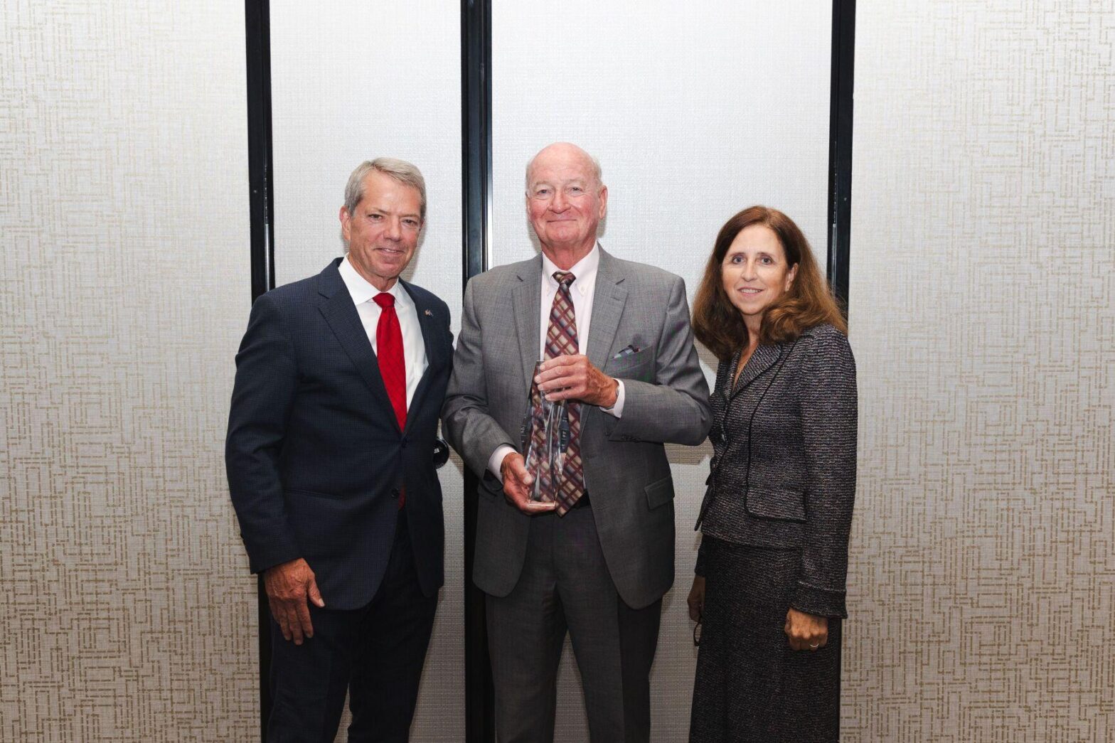 Owen Palm, recipient of the Diplomat of the Year award, alongside Nebraska Governor Jim Pillen and Nebraska Diplomats President Desiree Wineland.