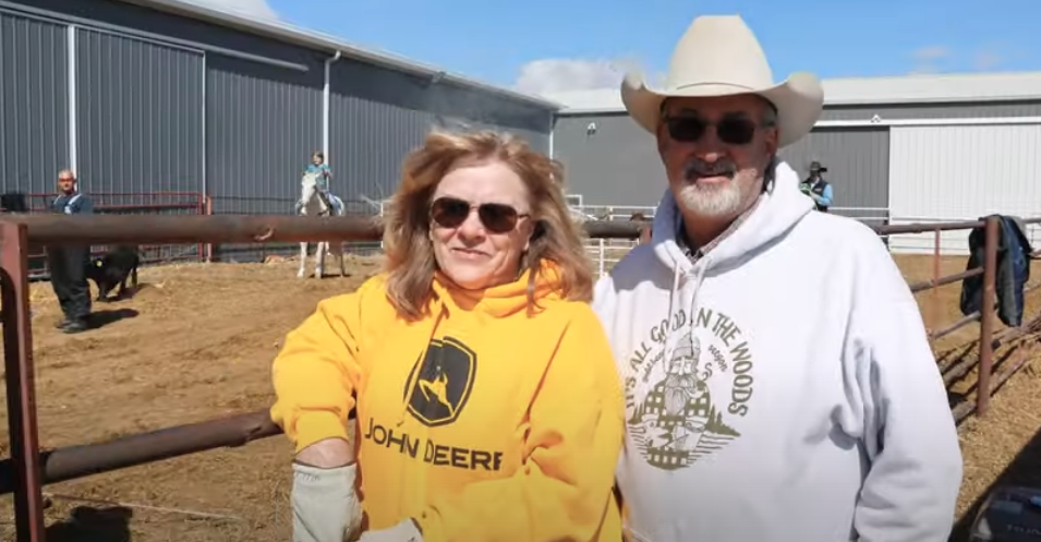 Two R&K Farms workers standing beside a horse corral.